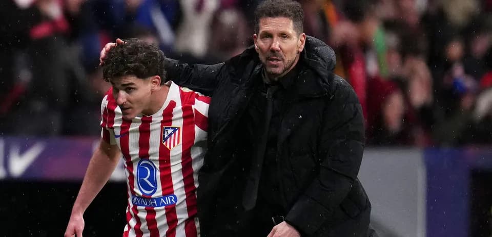 Entraîneur aidant un joueur d'Atlético sur le terrain