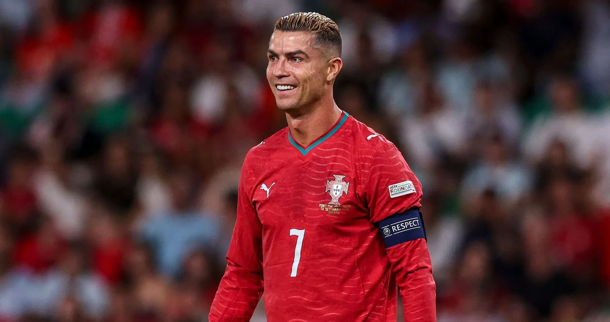 Joueur portugais en tenue rouge souriant sur le terrain