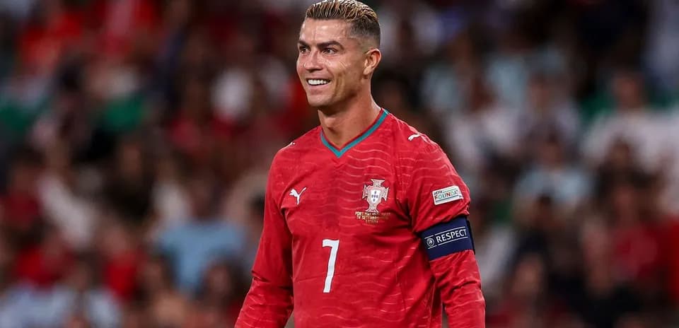 Joueur portugais en tenue rouge souriant sur le terrain