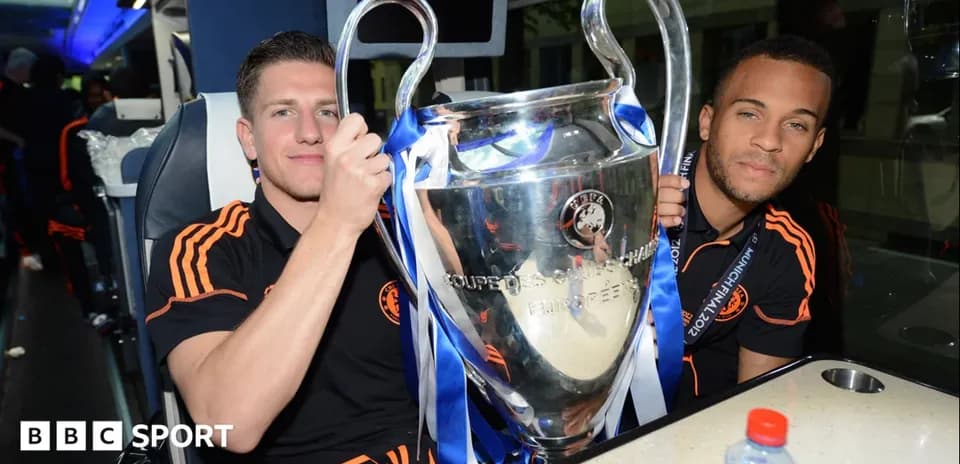 Joueurs tenant la Ligue des champions dans un bus