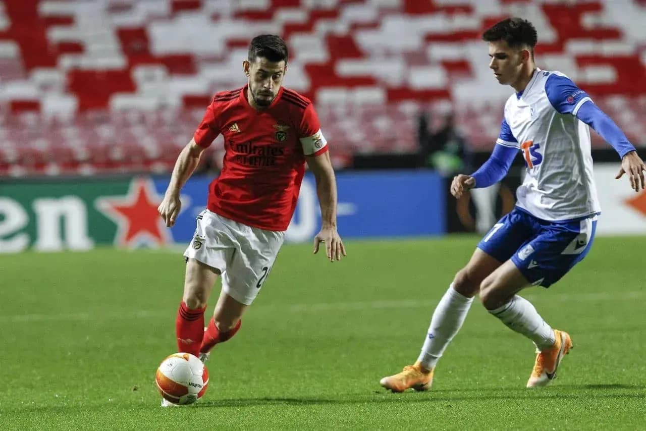 Joueur de Benfica dribblant un adversaire de Lech Poznan