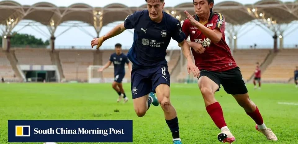 Joueur en bleu dribblant sous pression d'un adversaire