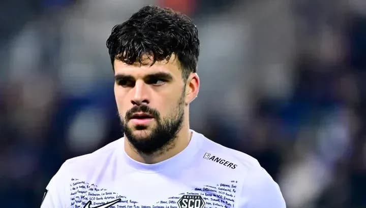 Joueur de football avec maillot blanc, regard sérieux