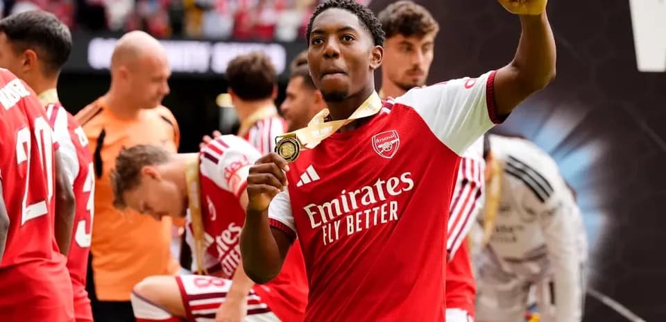Joueur d'Arsenal levant sa médaille de victoire