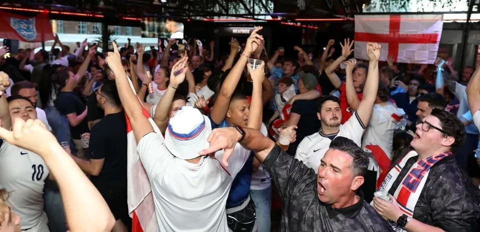 Supporters celebrating in a crowded pub during match