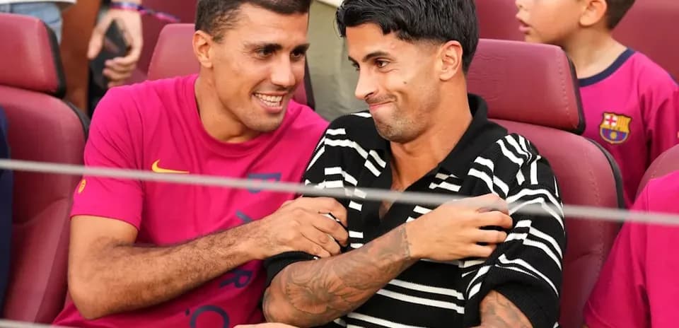 Deux joueurs souriant assis dans des sièges de stade