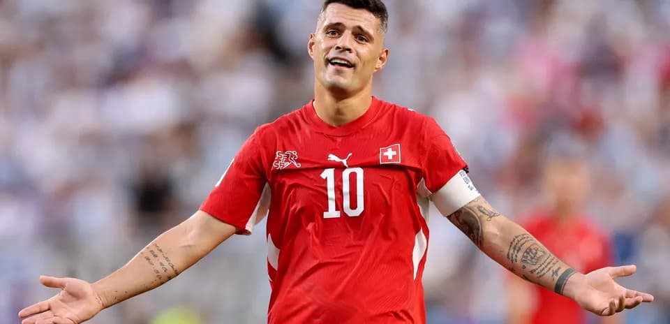 Joueur suisse en maillot rouge, bras levé en geste