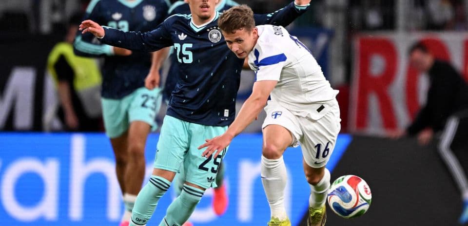 Joueur de Finlande dribblant sous pression allemande
