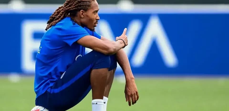 Joueur assis sur le terrain avec un ballon