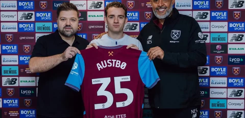Joueur tenant un maillot avec des entraîneurs à la signature
