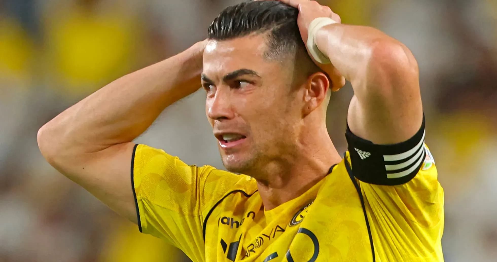 Joueur en maillot jaune se tenant la tête