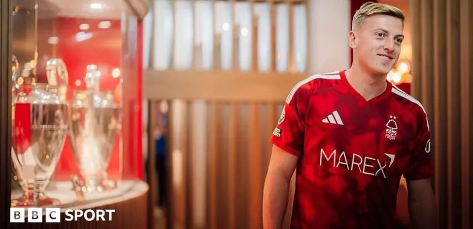 Joueur portant le maillot de Nottingham Forest près des trophées