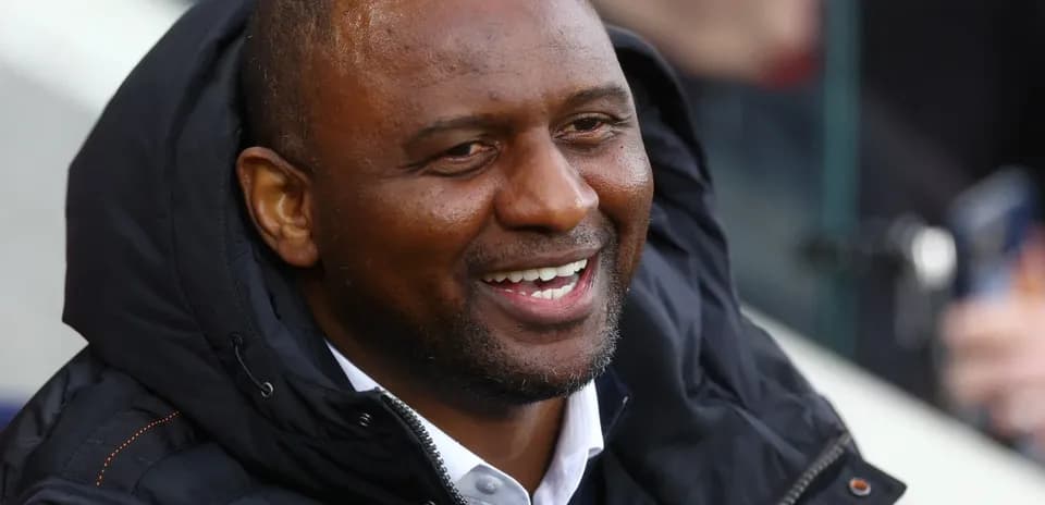 Homme souriant en veste lors d'un match