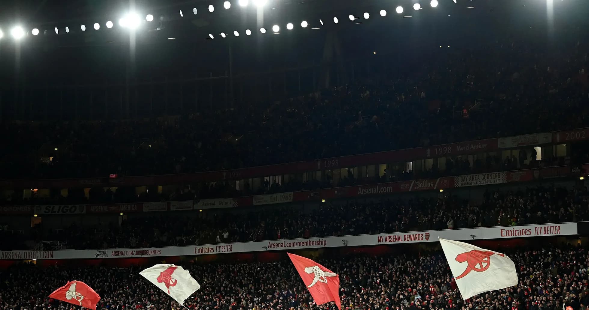 Supporters waving flags at Emirates Stadium during match