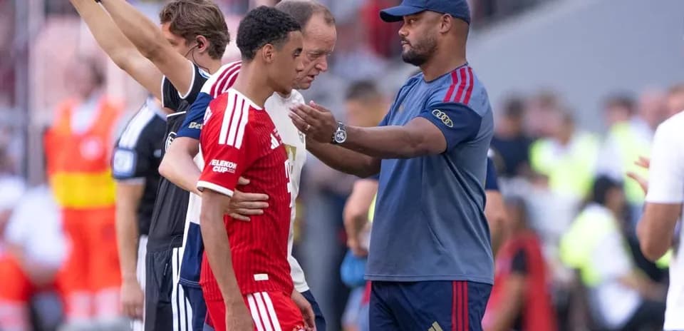 Entraîneur discutant avec joueur remplacé sur le terrain