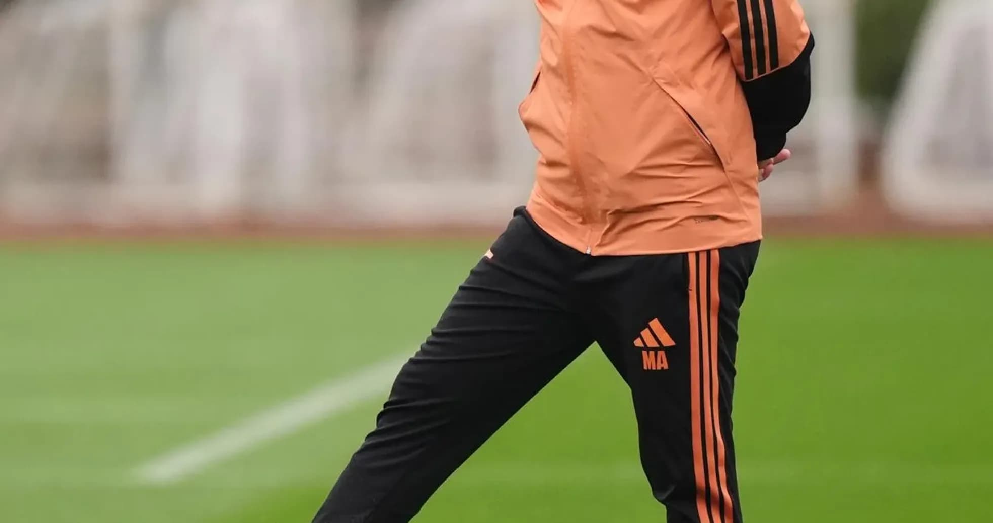 Entraîneur posant un pied sur un ballon de football