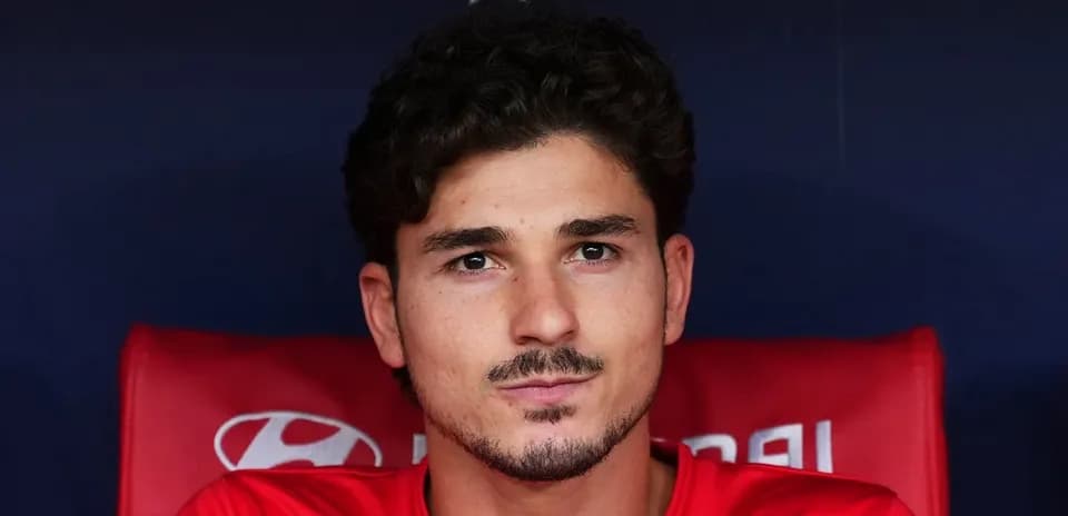 Joueur assis sur le banc de touche en maillot rouge