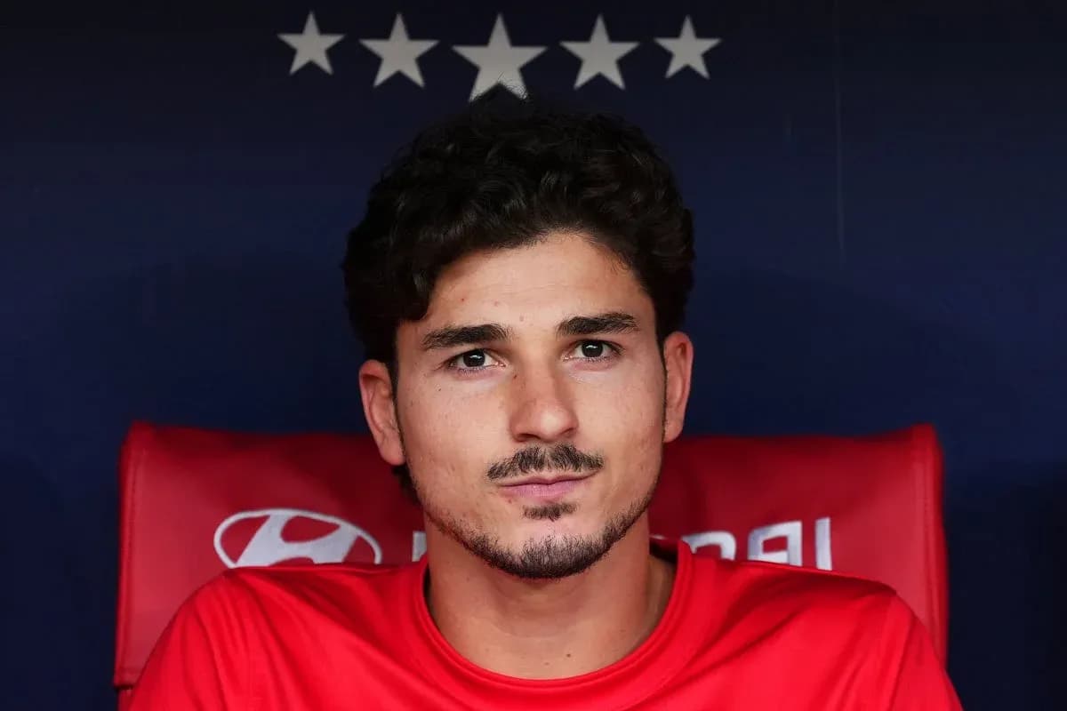 Joueur assis sur le banc de touche en maillot rouge