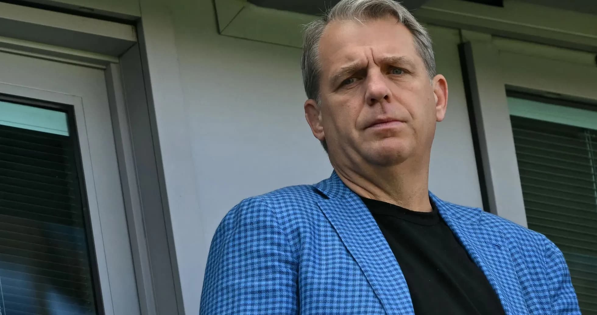 Homme en blazer bleu observant depuis une loge