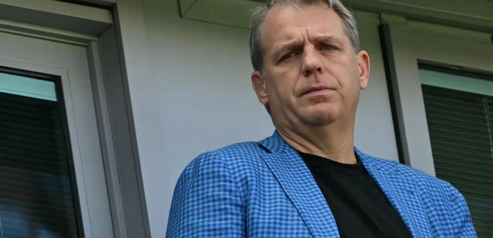 Homme en blazer bleu observant depuis une loge