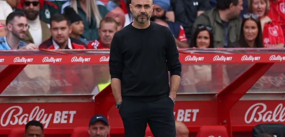 Entraîneur debout sur le banc de touche lors du match