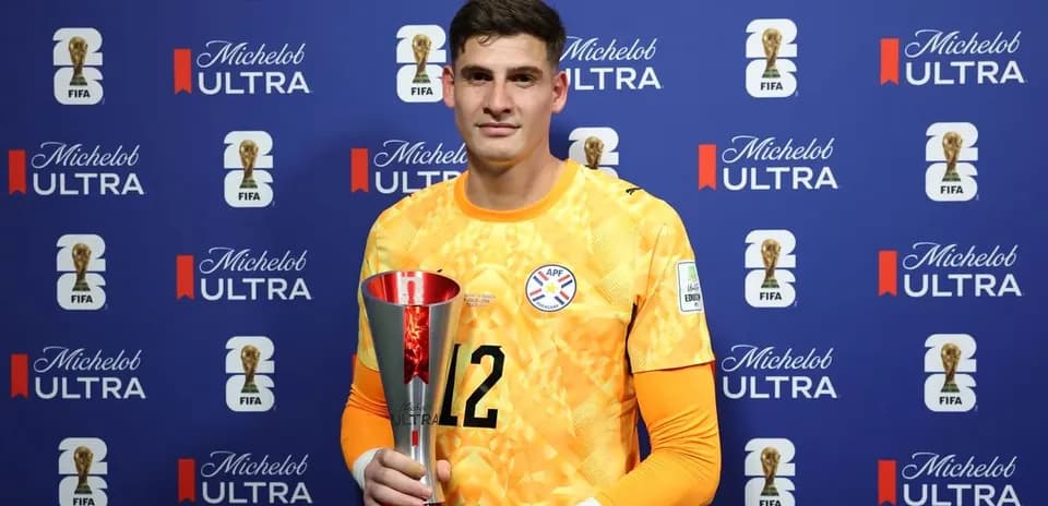 Gardien tenant un trophée devant un fond sponsor
