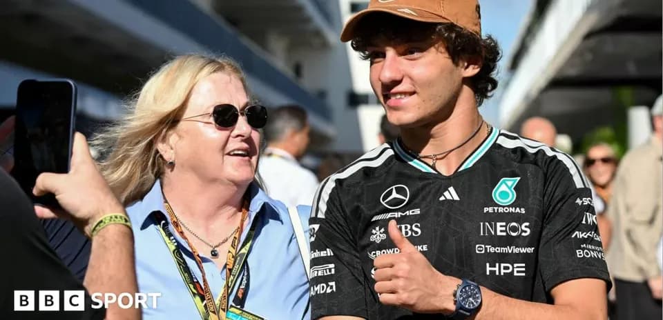 Deux personnes souriant dans un paddock de Formule 1