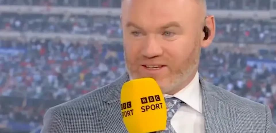 Commentateur avec micro devant un stade plein