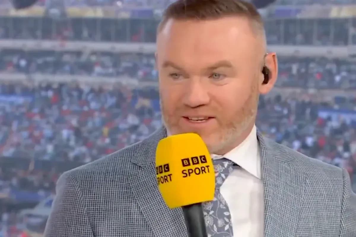 Commentateur avec micro devant un stade plein