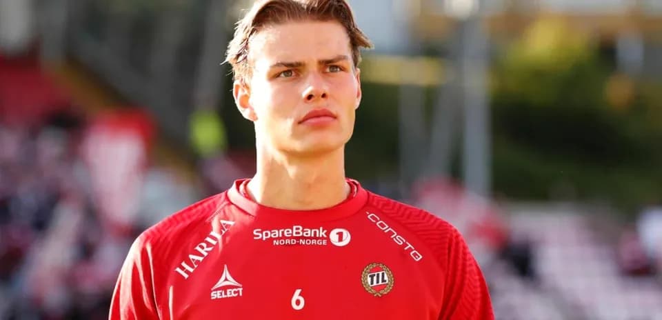 Joueur en tenue rouge sur le terrain avant le match