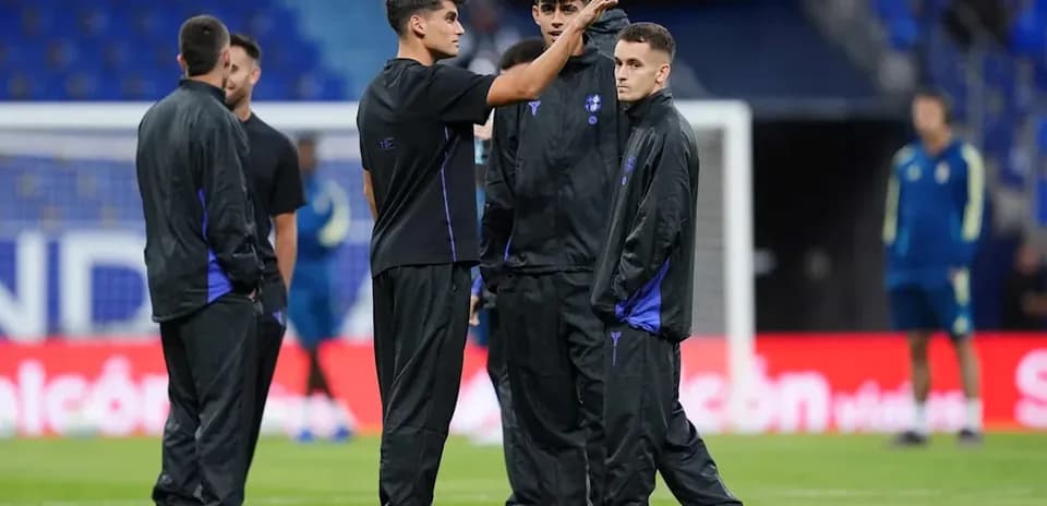 Joueurs discutant sur le terrain avant l'entraînement