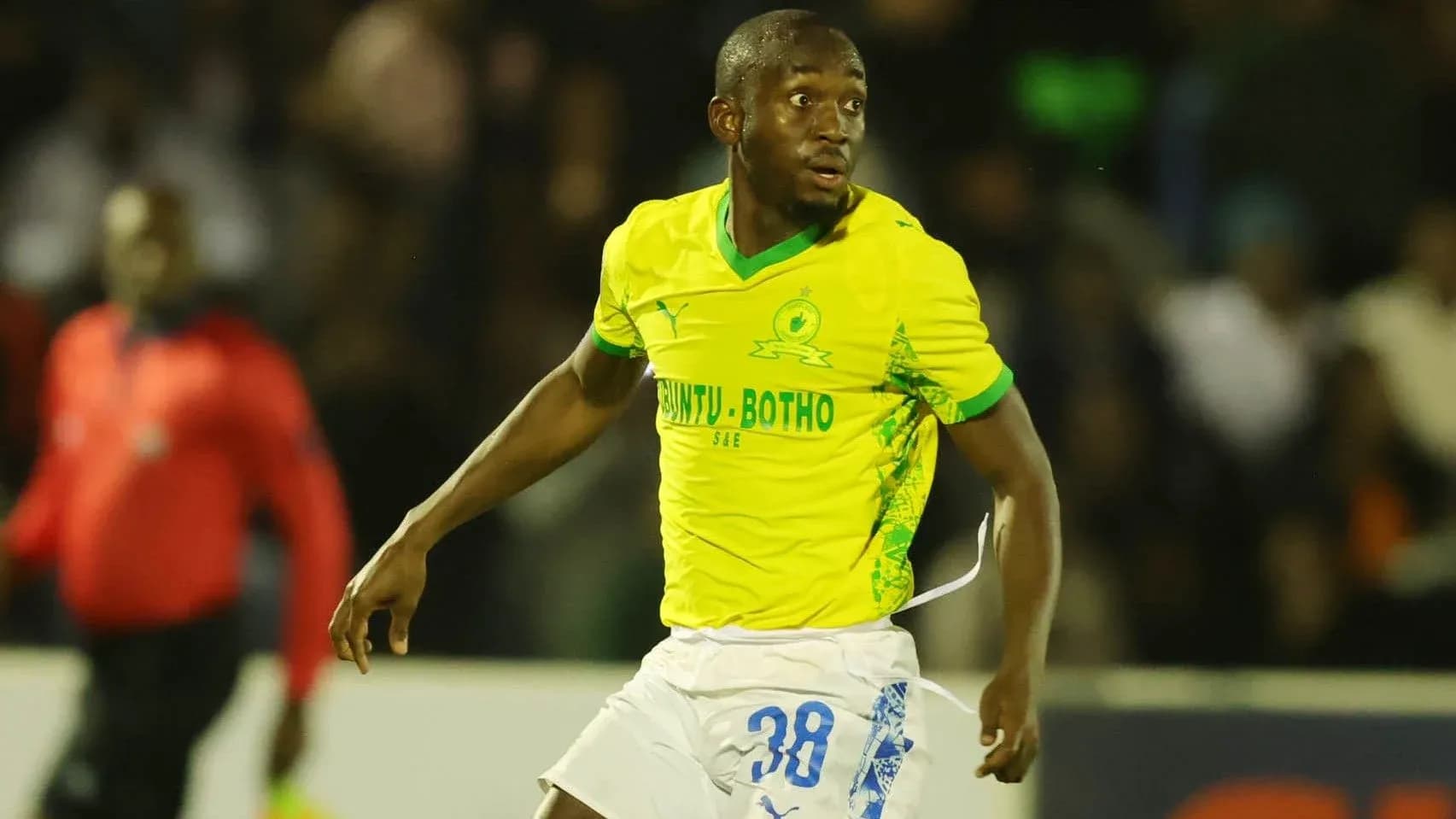 Joueur en action sur le terrain avec maillot jaune