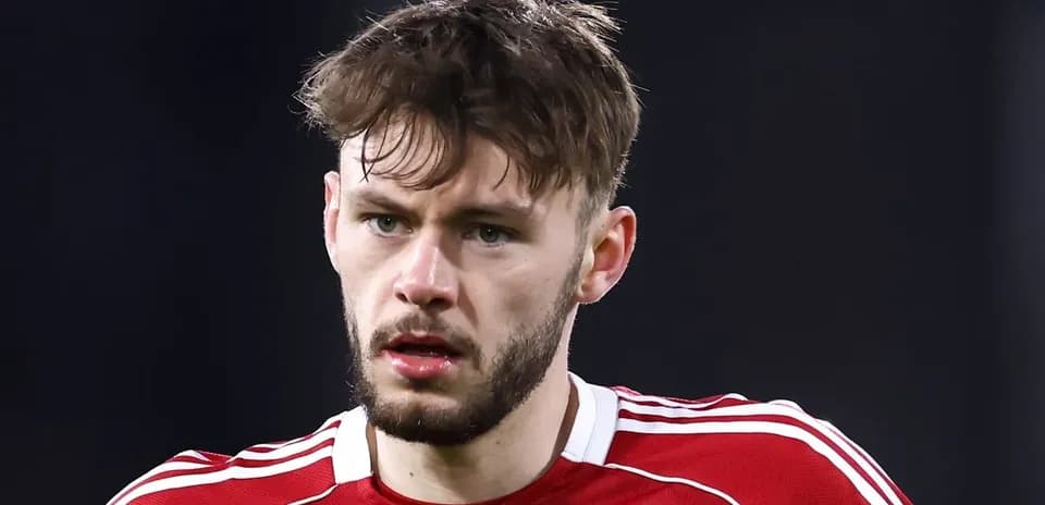 Joueur de football en maillot rouge, regard sérieux