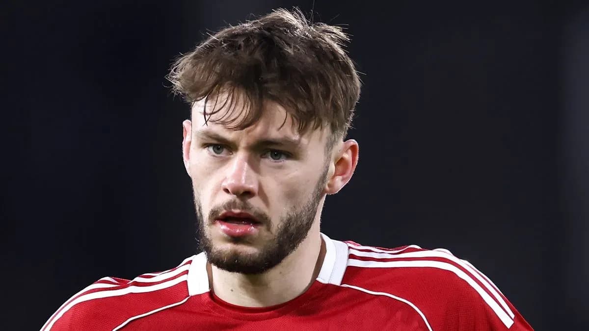 Joueur de football en maillot rouge, regard sérieux