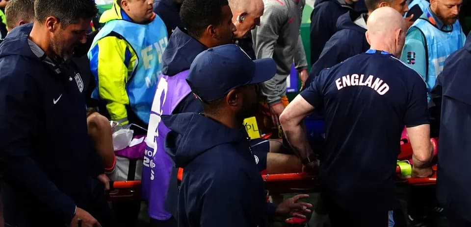 Staff assisting injured player off the field