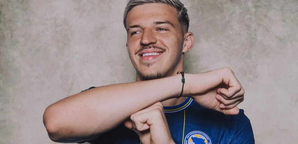 Joueur souriant en maillot bleu avec logo