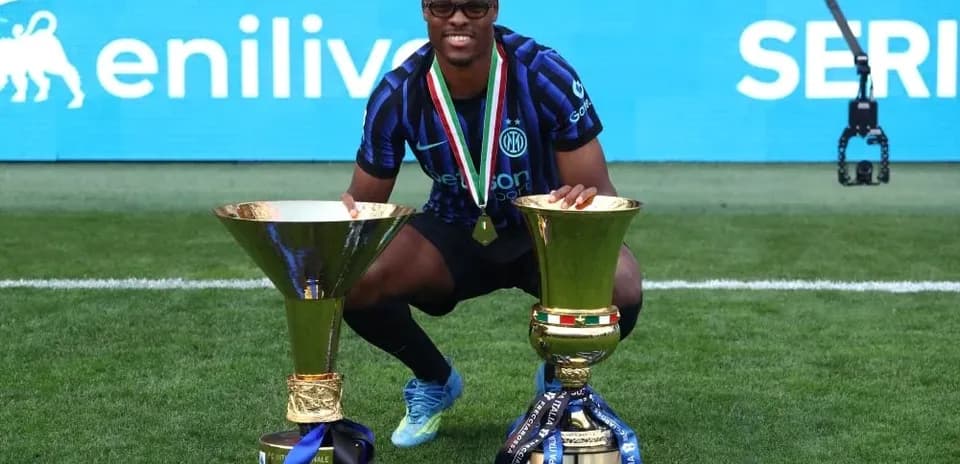 Joueur célébrant avec deux trophées de football