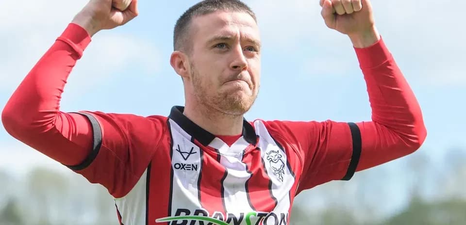 Joueur célébrant avec les bras levés sur le terrain
