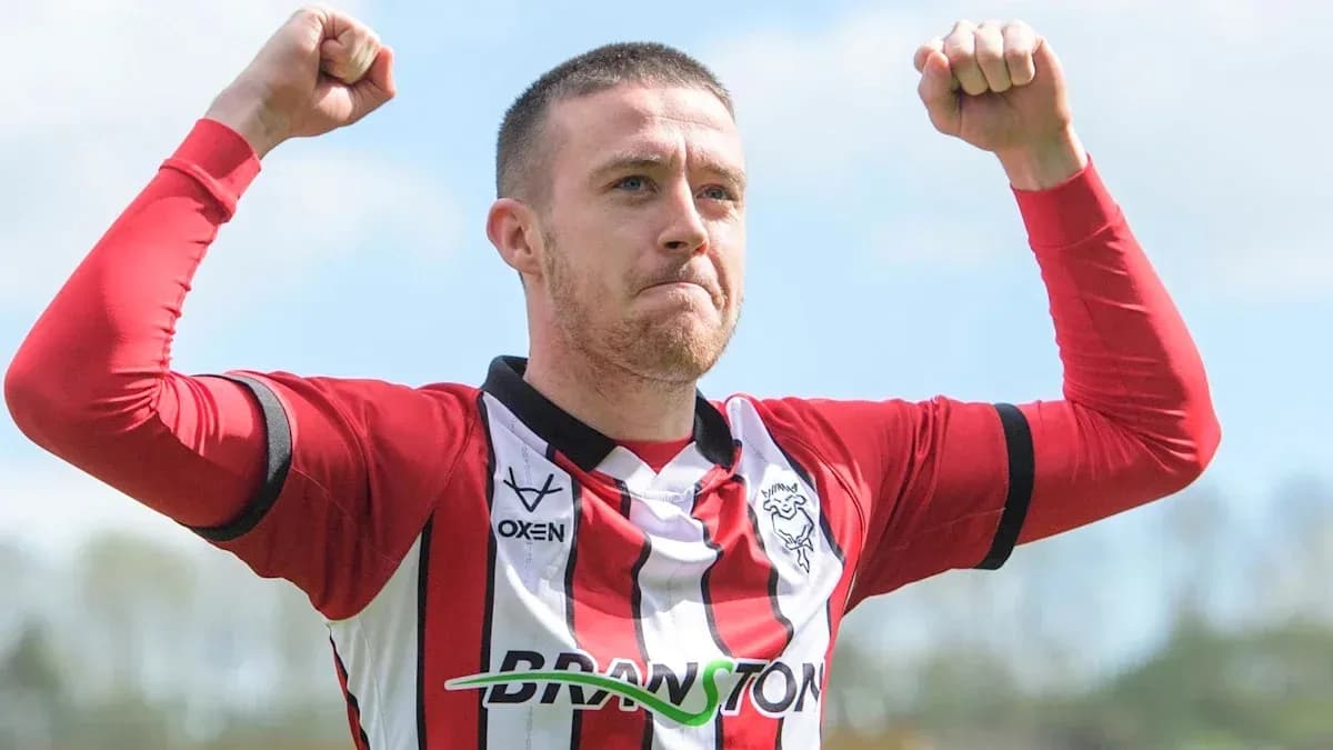 Joueur célébrant avec les bras levés sur le terrain