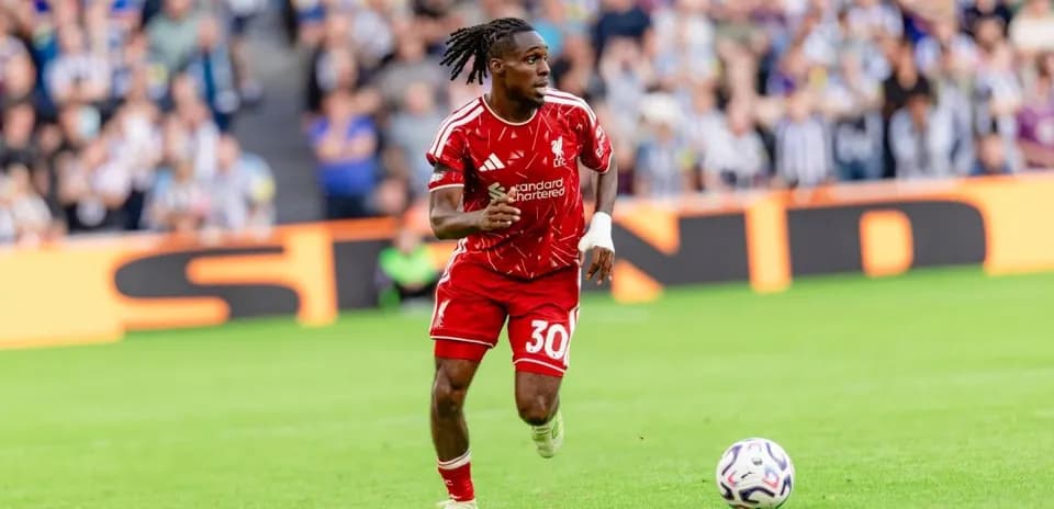 Joueur en maillot rouge courant avec le ballon