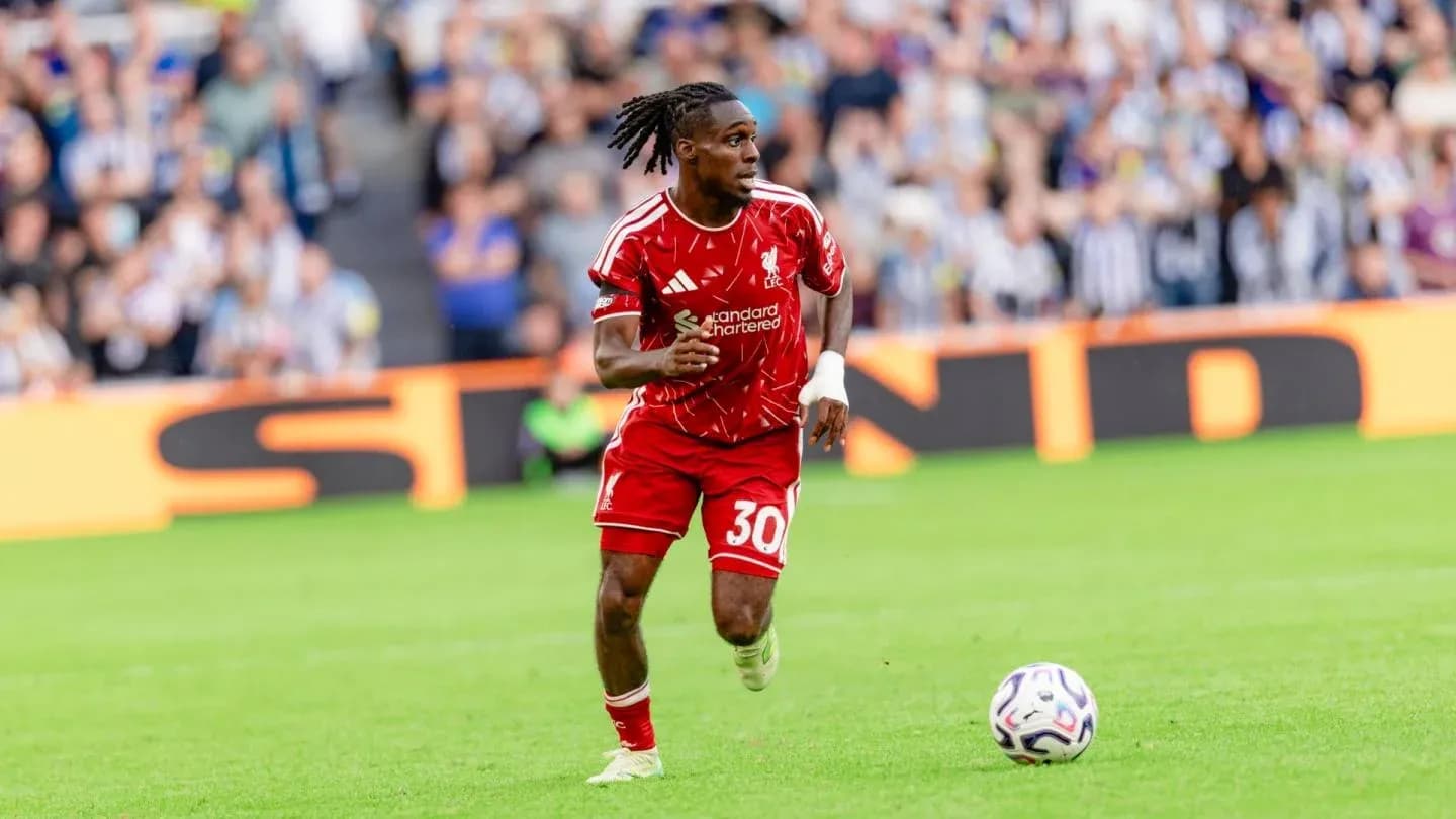 Joueur en maillot rouge courant avec le ballon