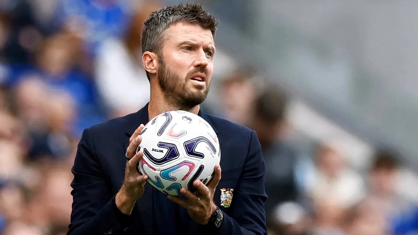Entraîneur tenant un ballon sur la touche