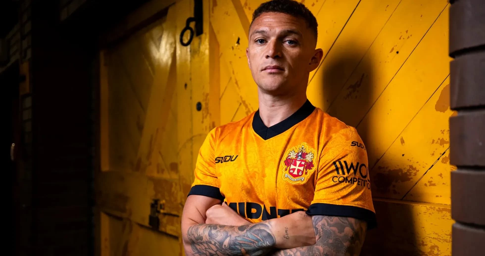 Joueur en maillot orange devant une porte jaune