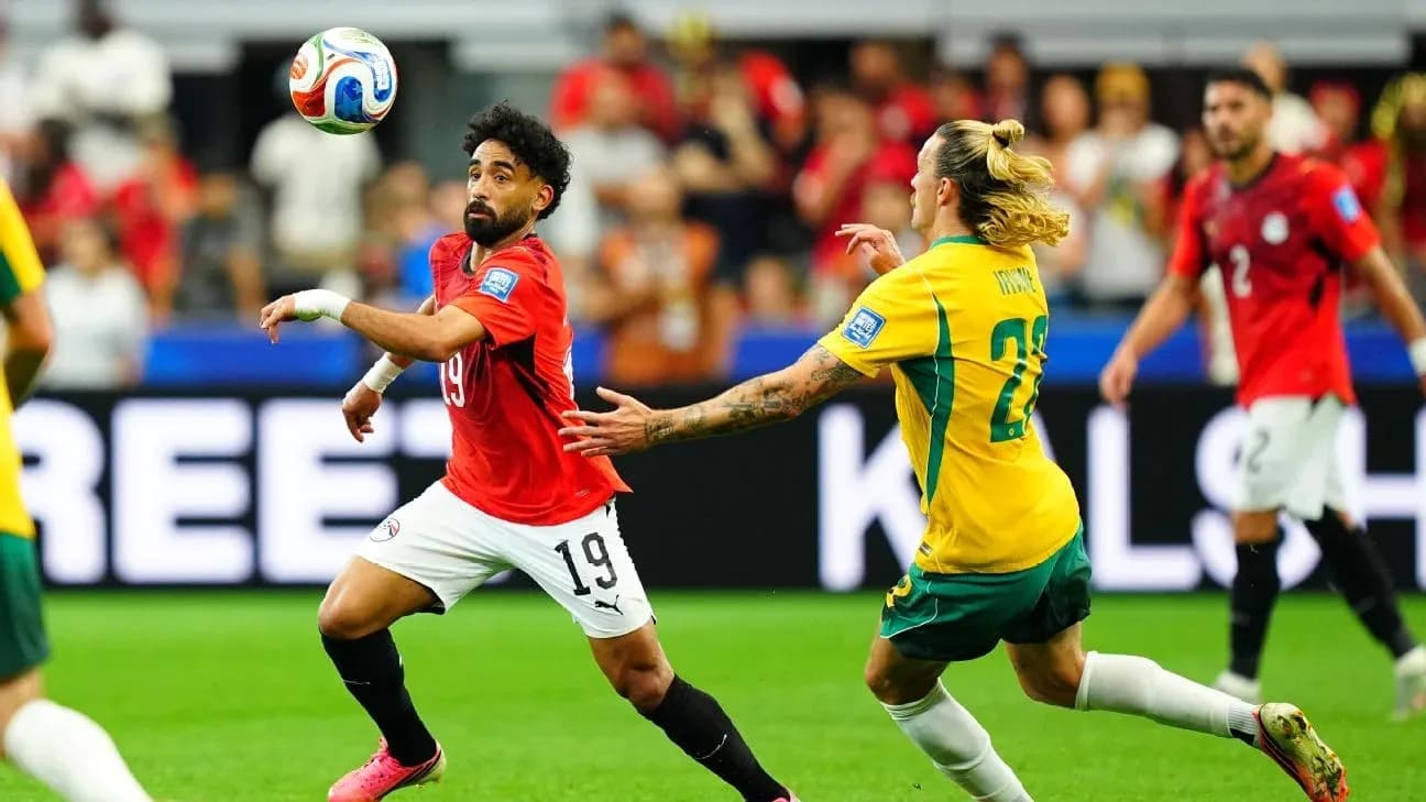 Joueur égyptien dribblant un adversaire australien Joueur égyptien dribblant un adversaire australien