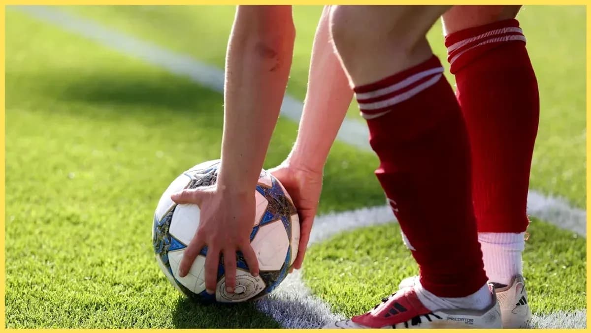 Joueur prenant un ballon de football pour un coup franc Joueur prenant un ballon de football pour un coup franc