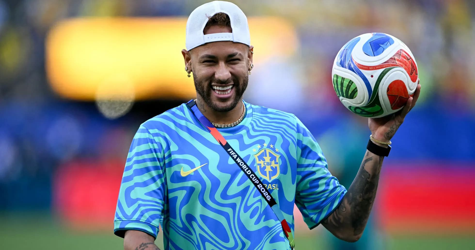Joueur souriant tenant un ballon de football Joueur souriant tenant un ballon de football