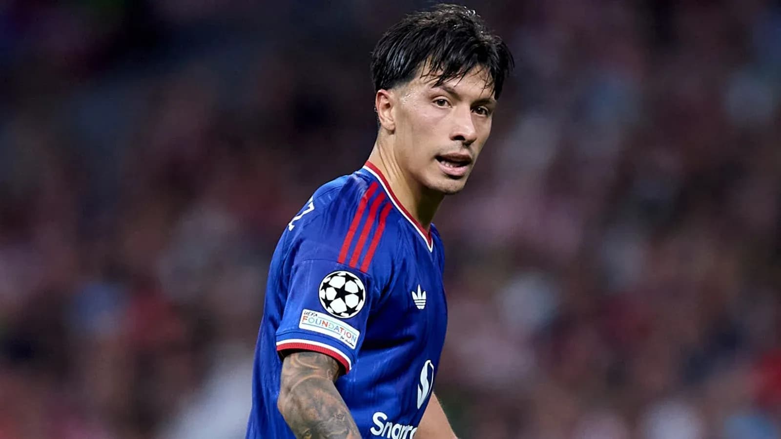 Joueur en maillot bleu sur le terrain de football Joueur en maillot bleu sur le terrain de football