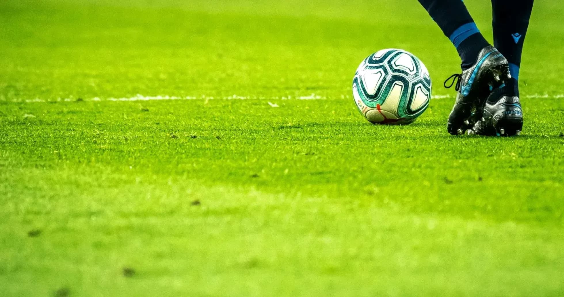 Un joueur s'apprête à frapper le ballon de football Un joueur s'apprête à frapper le ballon de football