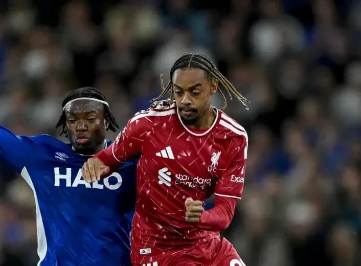 Joueur de Liverpool dribblant un adversaire en bleu Joueur de Liverpool dribblant un adversaire en bleu
