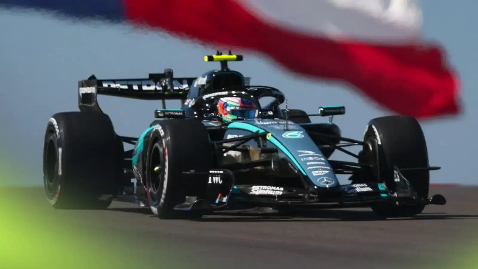 Voiture de Formule 1 en course avec drapeau en arrière-plan Voiture de Formule 1 en course avec drapeau en arrière-plan